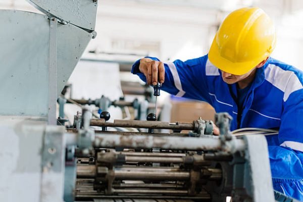 Blue collar worker or engineer working in industrial production plant, dealing with metal processing, hydraulic machinery, production lines and other pprocessing industry machines. Image taken in Serbia, Europe.